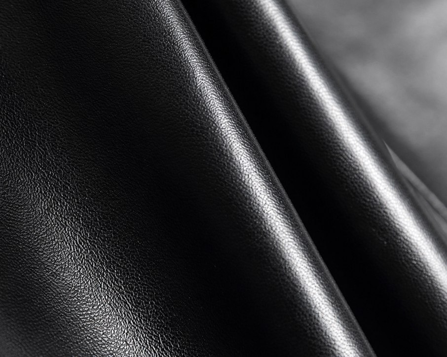 Close-up of the black faux leather surface and folds.