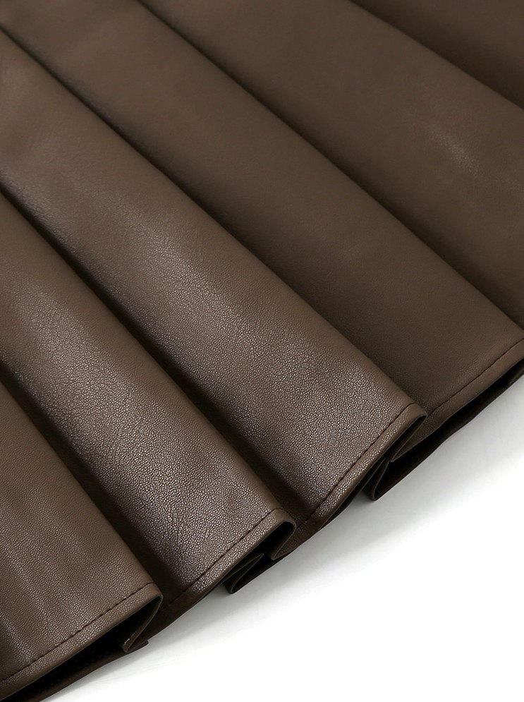 Close-up of the brown skirt pleats, faux leather surface and hem stitching.